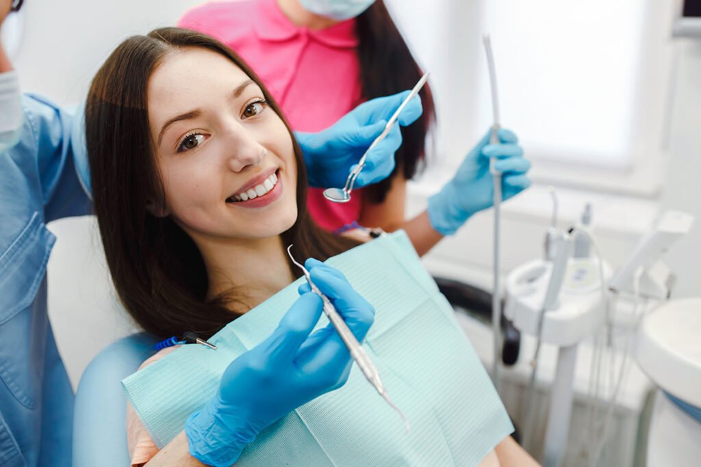 Happy female patient smiling in a dental chair during an examination