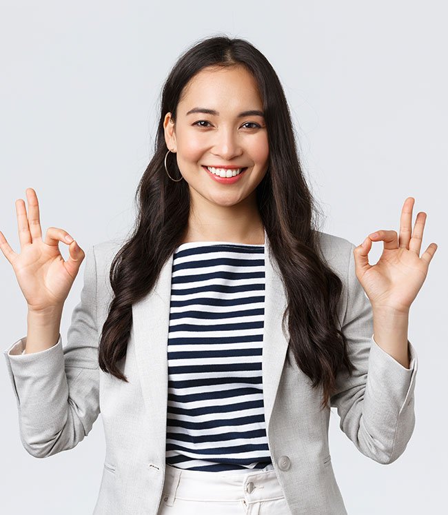 Smiling woman giving "OK" hand gestures, indicating satisfaction or approval.