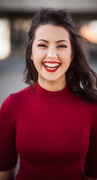 Smiling woman with bright, healthy teeth and red lipstick.