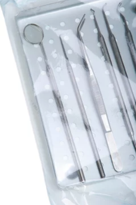 A sterile, sealed package of dental instruments, including a mirror, probe, and tweezers, ready for use.