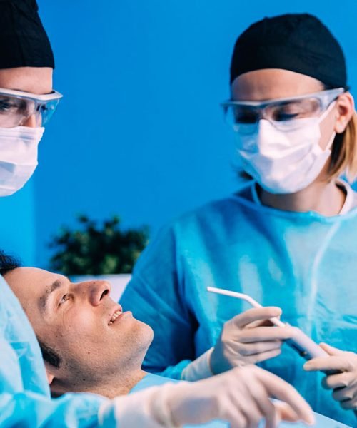 Dental professionals preparing to treat a patient in a sterile environment.